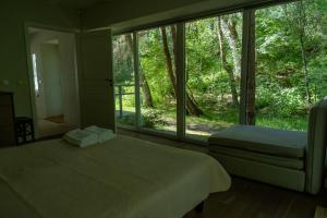 a bedroom with a bed and a large window at Nidos SKALVA in Neringa