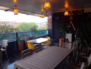 a dining room with a table and chairs on a balcony at Hotel Aura Nutibara in Medellín