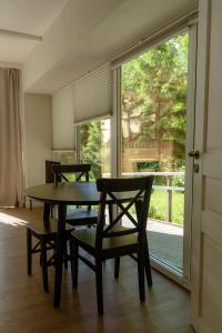 a dining room with a table and chairs and a window at Nidos SKALVA in Neringa +54 photos
