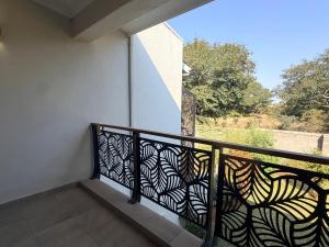 a balcony with a black railing with a view of a yard at Dreams Apartments in Victoria Falls