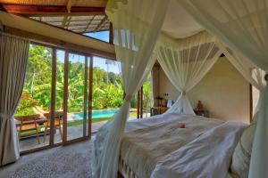 a bedroom with a canopy bed and a pool at Sayuban Villa in Susut