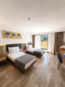 a hotel room with two beds and a desk at Pamukkale Kaya Termal Otel in Pamukkale +88 photos