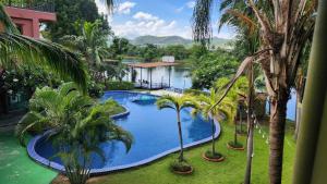 an overhead view of a swimming pool with palm trees at Utime Riverside Kanchanaburi in Ban Yang (2)