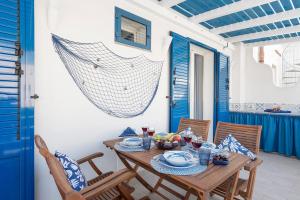 a dining room with a wooden table and chairs at Suite Horizon Marine in San Vito lo Capo