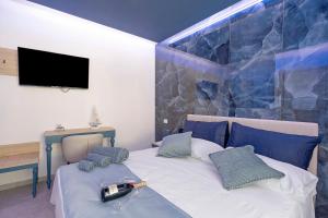 a bedroom with a bed with a tv on the wall at Suite Horizon Marine in San Vito lo Capo