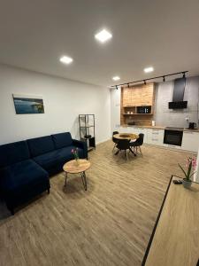 a living room with a blue couch and a table at Olmar Przybrodzin in Przybrodzin