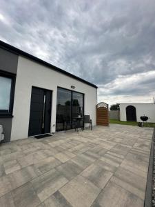 a white building with a patio with a table at Olmar Przybrodzin in Przybrodzin