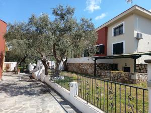 a fence in front of a house with a tree at Villa Elli in Limenas