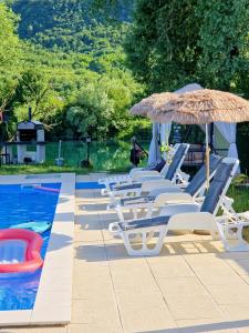 a group of chairs and umbrellas next to a swimming pool at Villa Lea in Bihać