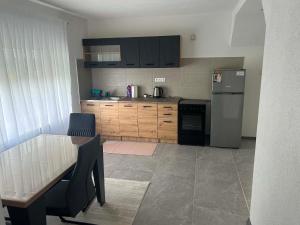 a kitchen with a table and a refrigerator at Apart centar Pliva , Jajce in Jajce
