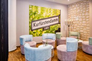 a waiting room with blue and purple chairs and a sign at Hotel Chateau Berlin Kurfürstendamm in Berlin