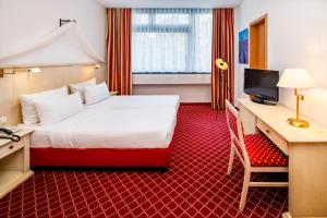 a hotel room with a bed and a desk and a television at Hotel Chateau Berlin Kurfürstendamm in Berlin