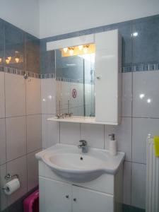 a bathroom with a white sink and a mirror at Nice & Cosy apartment in Igoumenitsa in Igoumenitsa +55 photos