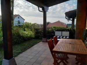 a wooden table and chairs on a patio at La Casuca de Pechón in Pechón +7 photos