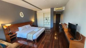 a hotel room with a bed and a television at Utime Riverside Kanchanaburi in Ban Yang (2)