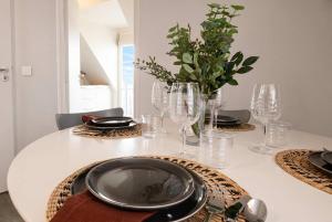 a white table with glasses and a plate on it at Sebastopol Chic Balcon & Parisian View in Paris