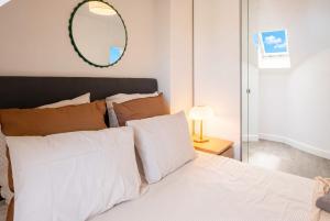 a bedroom with a white bed with a mirror on the wall at Sebastopol Chic Balcon & Parisian View in Paris +10 photos