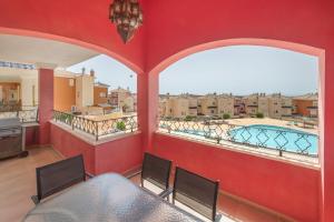 a balcony with a table and chairs and a pool at Sun & Golf Stay in Baños y Mendigo