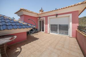 a patio of a house with a pink at Sun & Golf Stay in Baños y Mendigo