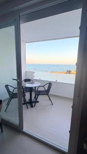 a balcony with a table and chairs and the ocean at La Perla Del Mar APARTAMENT in Torrevieja