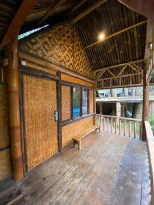 a large wooden porch with a bench on a deck at Cozzy Mutiara Rahong in Pengalongan
