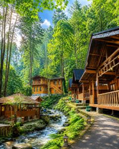 a river running through a forest with wooden buildings at Cozzy Mutiara Rahong in Pengalongan