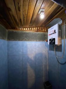 a bathroom with a fan and a blue wall at Cozzy Mutiara Rahong in Pengalongan
