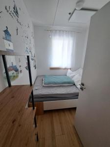 a small bed in a small room with a window at Ferienhaus am Edersee-scheid in Waldeck