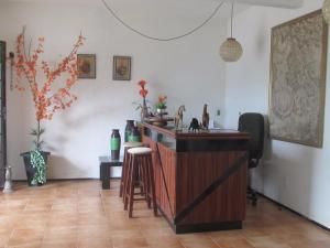 a bar with stools in a room with white walls at Pousada Sitio Costa Verde in Ubajara
