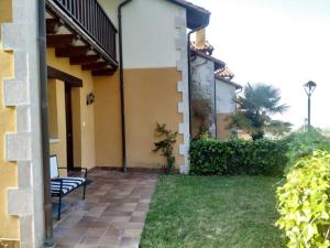 a bench sitting outside of a house with a yard at La Casuca de Pechón in Pechón