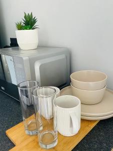 a table with plates and cups and a microwave at Koshoka Home in Ompanda