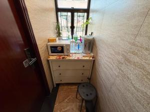 a room with a table with a microwave and a chair at Sleep Inn in Hong Kong