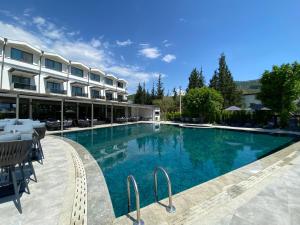 a large swimming pool in front of a hotel at Göcek Lykia Resort Premium Concept Hotel in Göcek