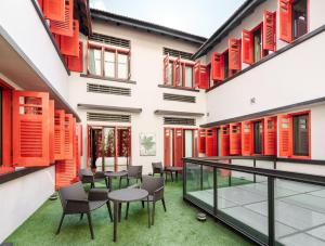 an internal courtyard of a building with red shutters at The Vagabond Club, a Tribute Portfolio Hotel Singapore in Singapore