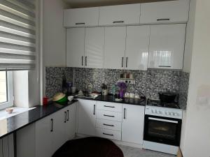 a kitchen with white cabinets and a stove at Уметалиев Канат in Birlik