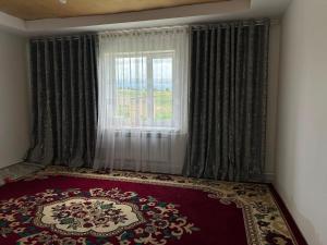 a room with a window with a red rug in front of a window at Уметалиев Канат in Birlik