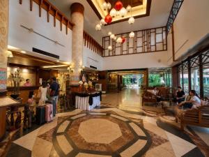 a lobby of a building with people sitting around a table at Chiangmai Gate Hotel in Chiang Mai +64 photos