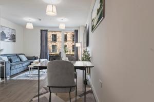 a living room with a table and a couch at Stylish 1-Bed flat with Private Balcony in Hatch End