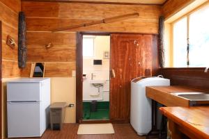 a kitchen with a refrigerator and a sink at おきなわ民泊海族 in Okinawa City