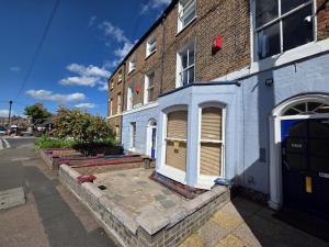 a brick building with a white door on a street at Parkview Guest House in King's Lynn