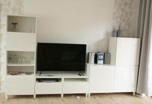 a white entertainment center with a flat screen tv at Ferienwohnung Möbus in Fritzlar