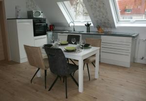 a kitchen with a table and chairs with wine glasses at Ferienwohnung Möbus in Fritzlar