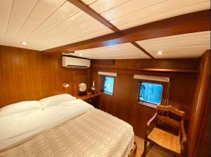 a bedroom in a boat with a bed and a chair at The Oak & Anchor - Hong Kong Houseboat in Hong Kong +41 photos