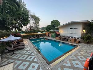 a swimming pool with chairs and an umbrella at Chiangmai Gate Hotel in Chiang Mai