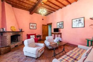 a living room with two chairs and a fireplace at Tenuta Bichi Borghesi in Monteriggioni