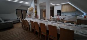 a long table with a white table cloth and chairs at Dom Na Chwilę in Brzozowa