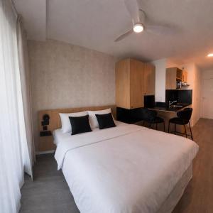 a bedroom with a large white bed and a desk at Sweetly La Rochelle in La Rochelle