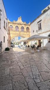 a bridge over a courtyard with tables and chairs at vabè apulian accommodation in Ostuni