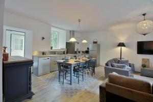a kitchen and living room with a table and chairs at La Maison d'Aure in Arreau