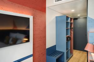 a room with a red wall and a blue book shelf at the niu Clink in Hamburg